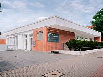 Gebäude aus roten Ziegelsteinen mit Praxislogo